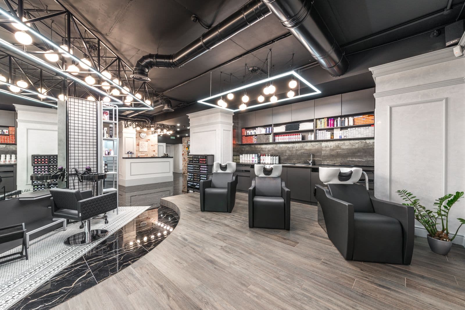 An empty, modern salon interior with backwash chairs and styling stations